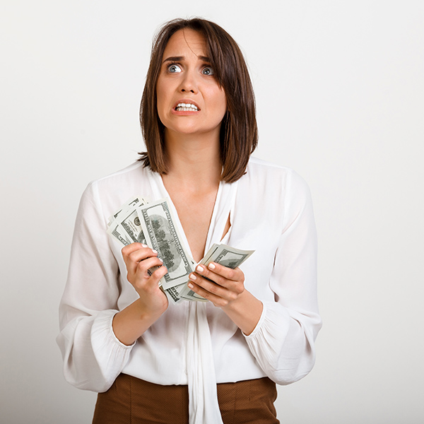 femme inquiète avec de l'argent à la main