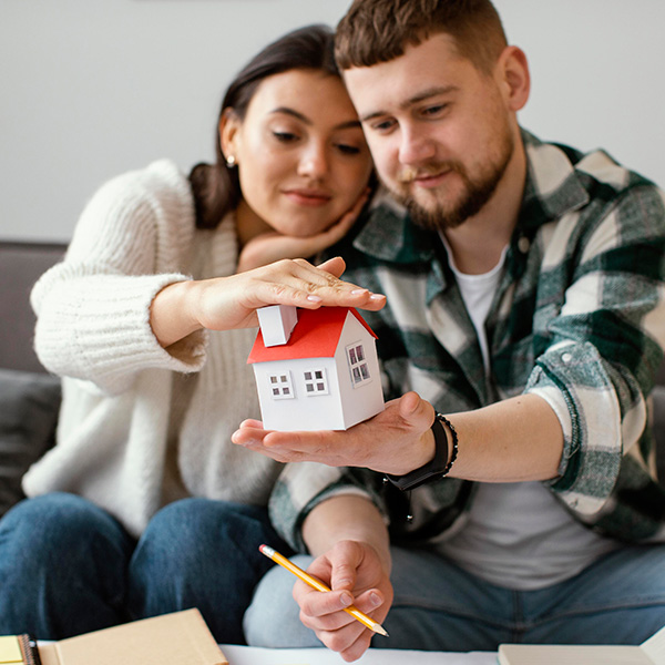 Un couple de jeunes observe un modèle de maison